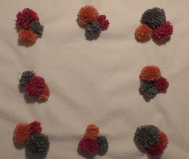 Pom Poms attached on front of cushion
